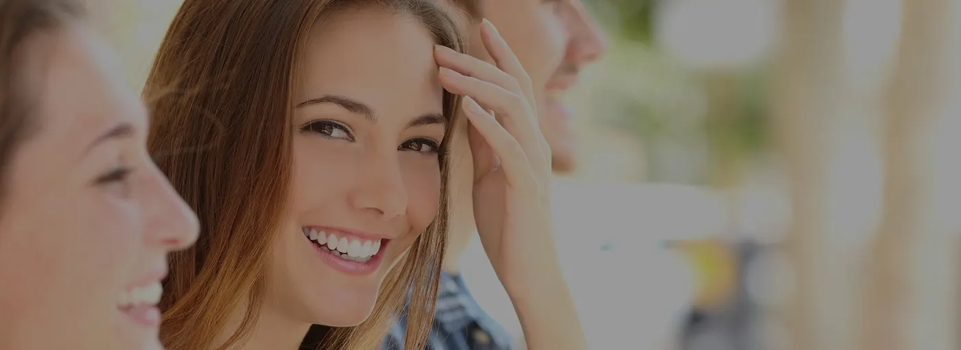A smiling young woman with two friends beside her