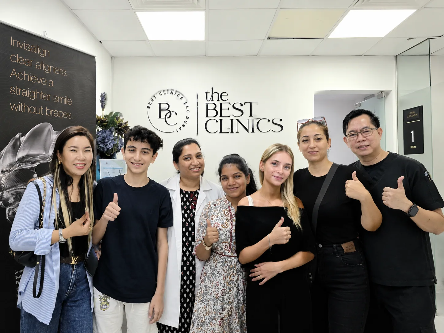 Best Dental Clinic team and patients in front of the clinic wall in Al Rigga, Dubai